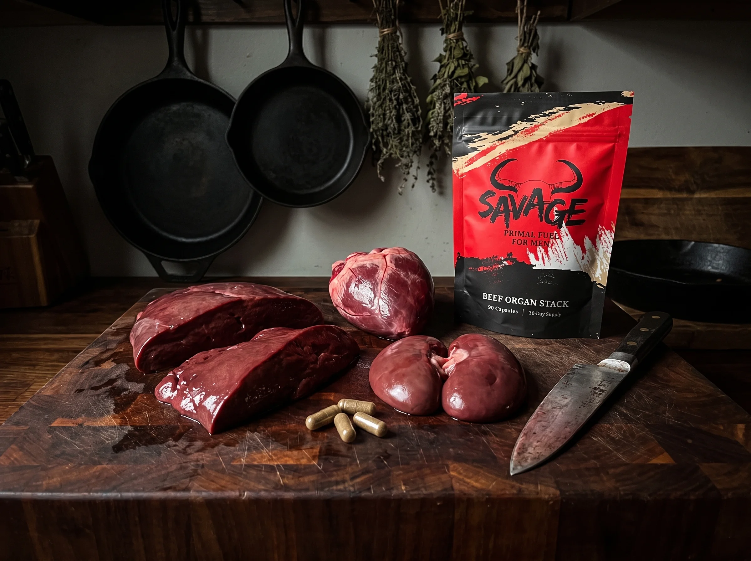 Raw grass-fed beef liver, heart, and kidney arranged on a dark wooden butcher block, deep red tones, a chef's knife off to th