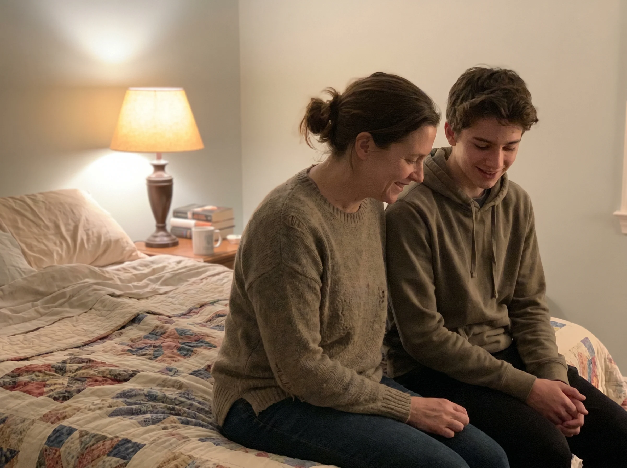 Parent and teenager sitting on the edge of a bed having a quiet conversation, both relaxed, soft bedroom lighting