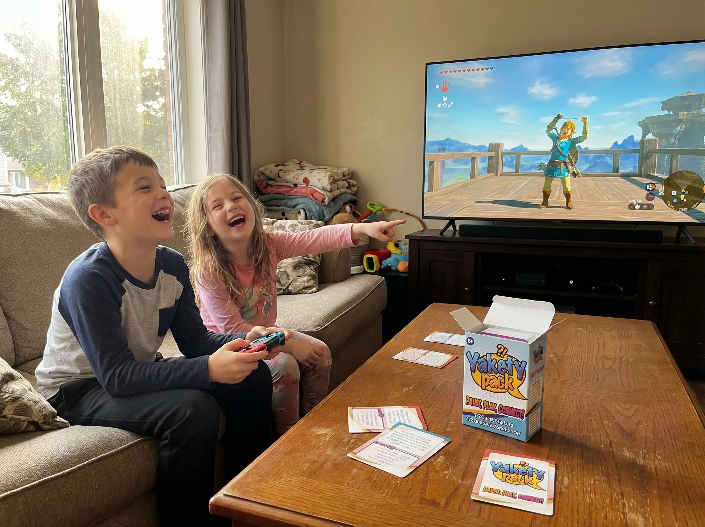 Two kids on the couch, one playing Zelda while the other excitedly points at the screen, both laughing at something that just