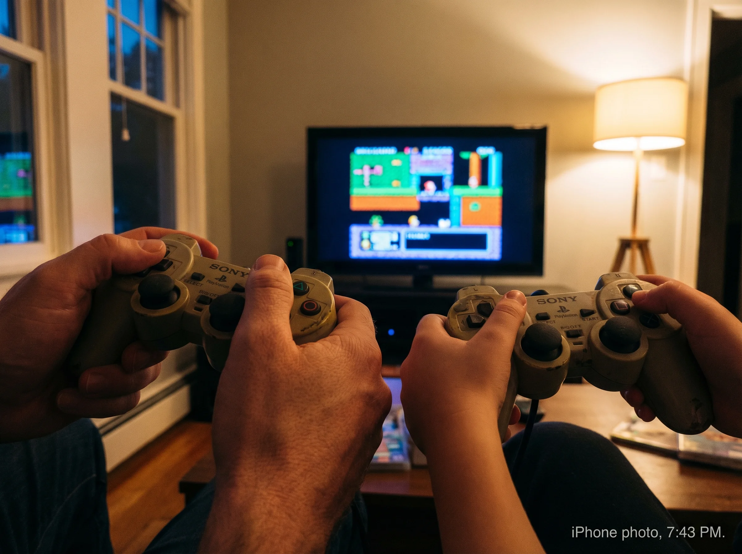 Close-up of parent and child hands both holding controllers, focused on the same screen, natural evening lighting