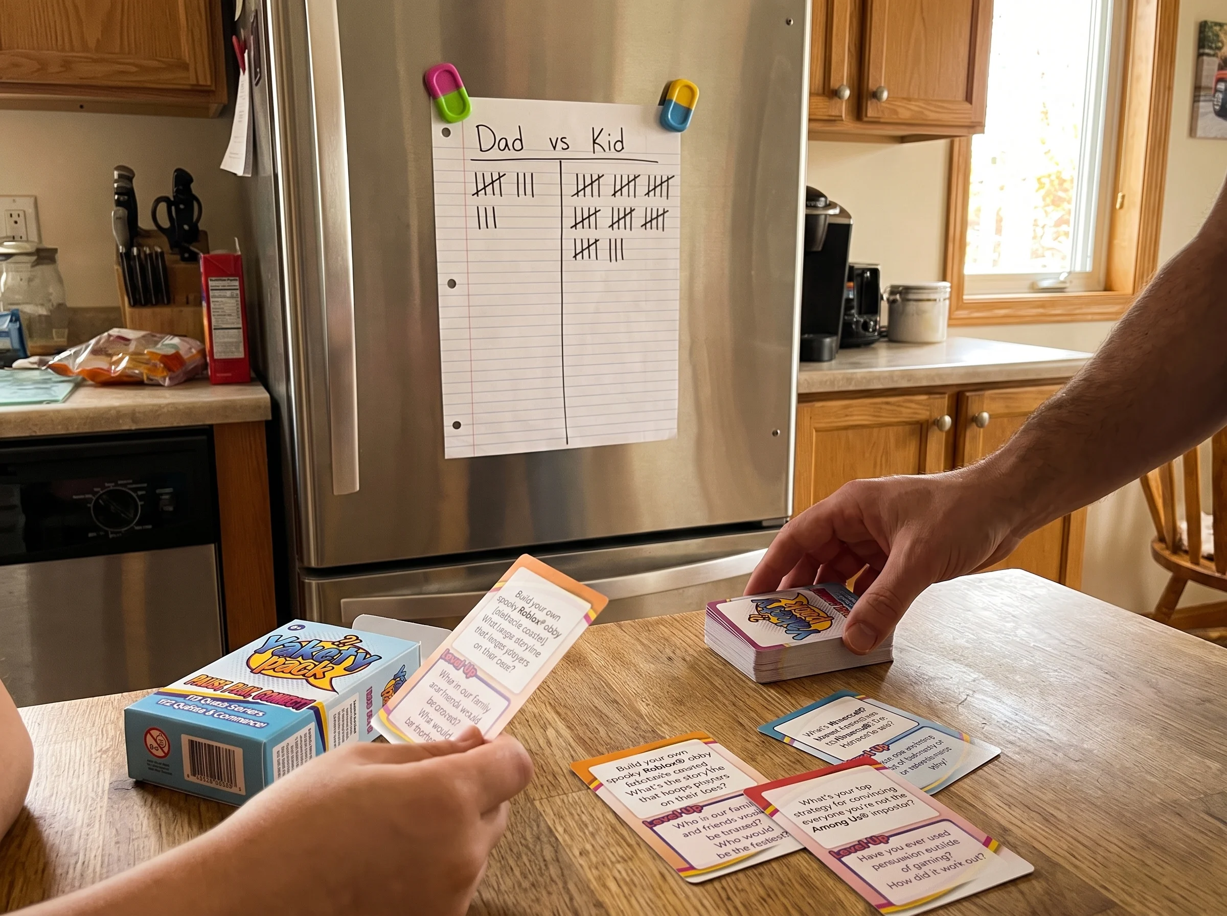 A handwritten scoreboard on a piece of paper stuck to a fridge with magnets, showing Dad vs Kid tally marks, kid clearly winn