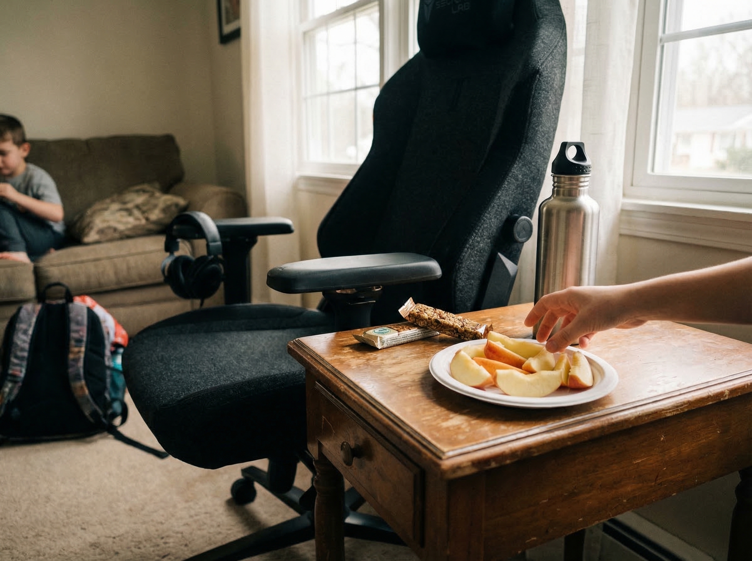 Healthy snacks arranged on a small table next to a gaming chair - apple slices, granola bars, and a water bottle within easy