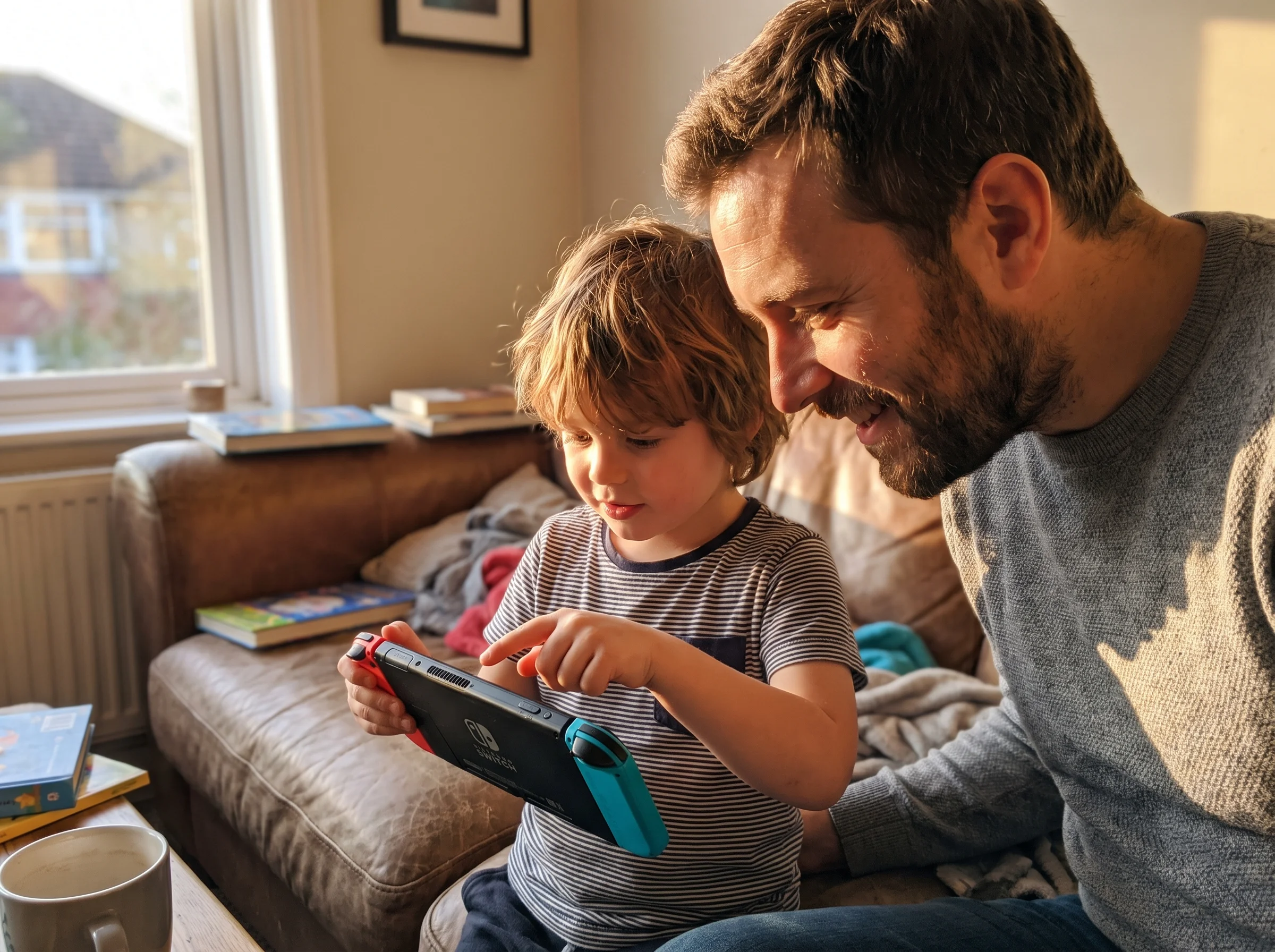 Kid showing a parent something on a Nintendo Switch screen, both leaning in close, late afternoon light, the parent looking g