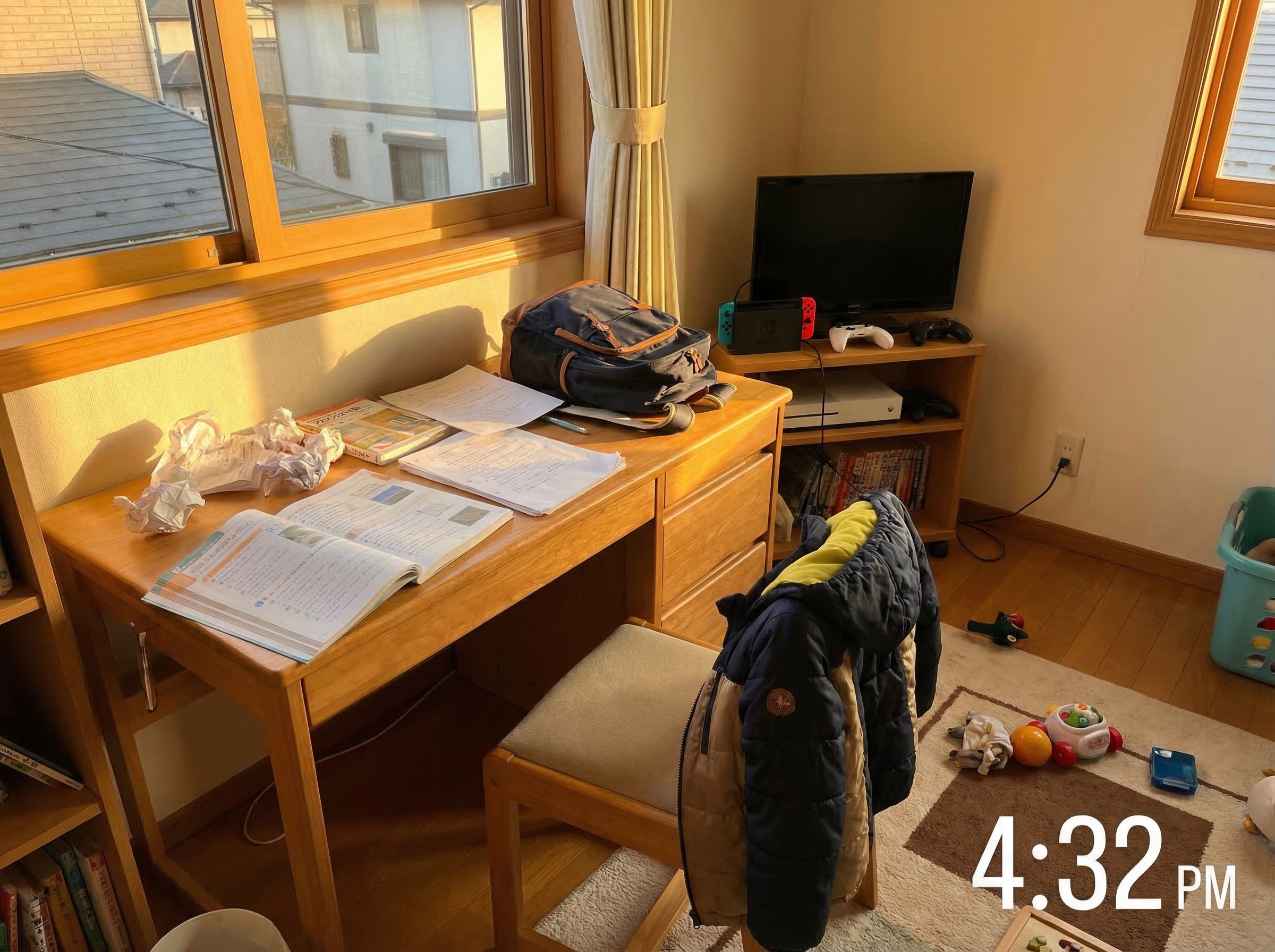 A child's bedroom showing a desk with homework scattered on it and a gaming console nearby, late afternoon light suggesting a