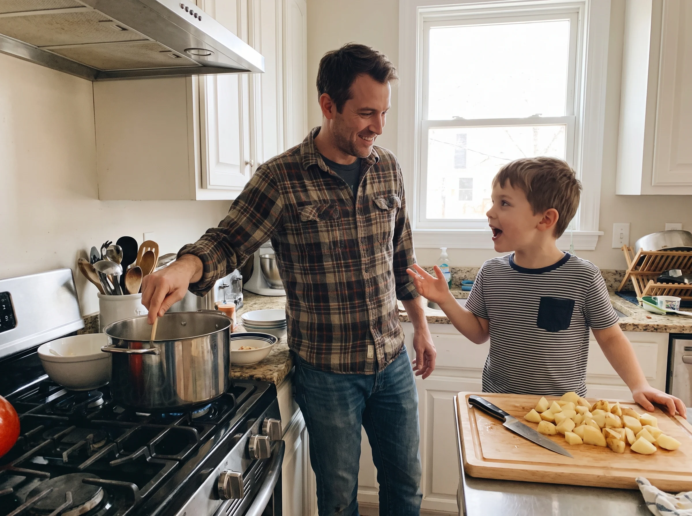 A kitchen scene where a dad and his son are cooking together, potatoes on a cutting board, both wearing casual clothes, son m