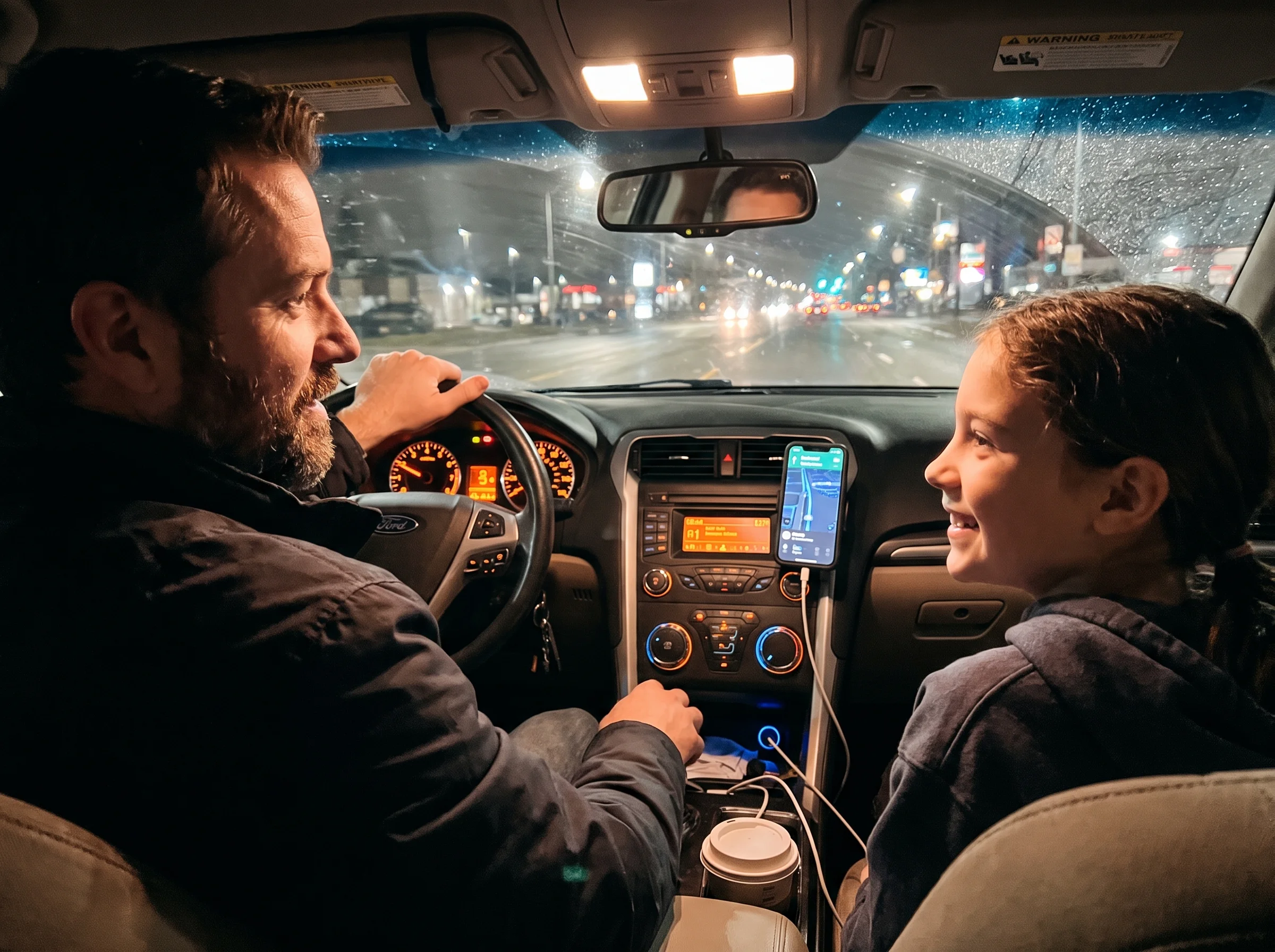 A father and tween daughter driving in a car at night, dashboard lights glowing, she's smiling and looking at him mid-convers
