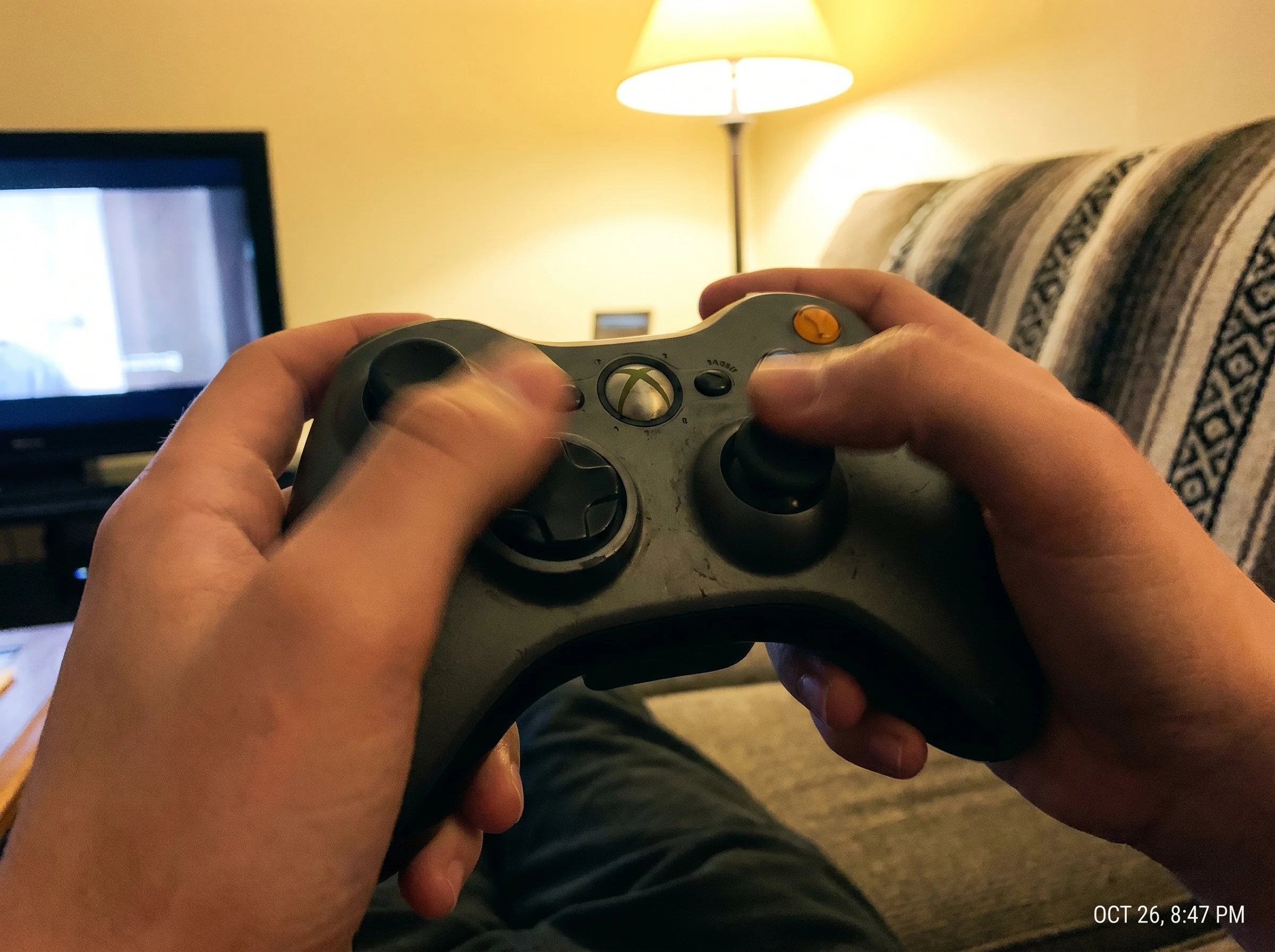 Close-up of a teen's thumbs in fast motion on a controller, slight blur to show speed, warm overhead lamp lighting
