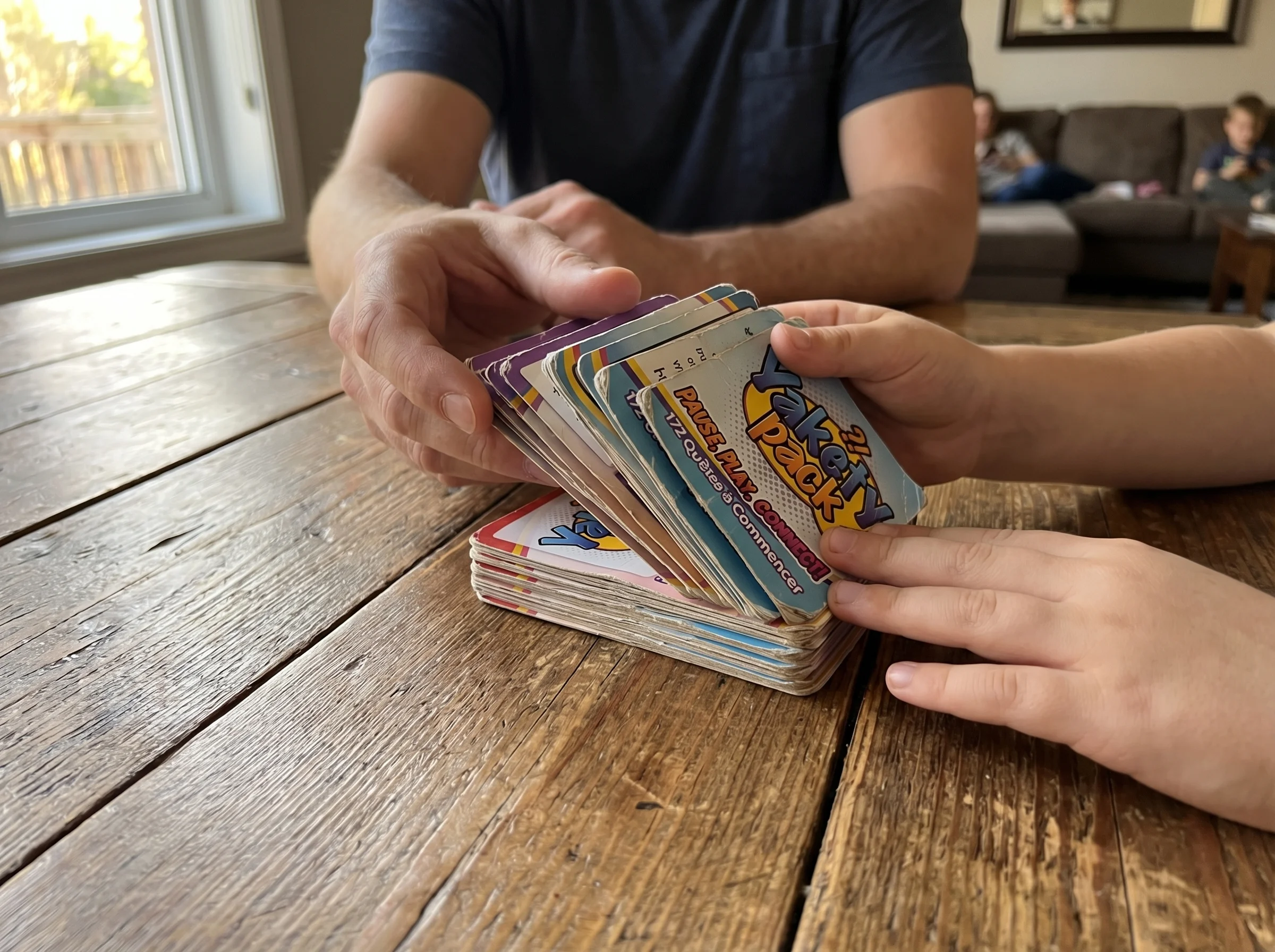 Close-up of hands shuffling worn playing cards on a wooden table, focus on the natural movement and texture of well-used card