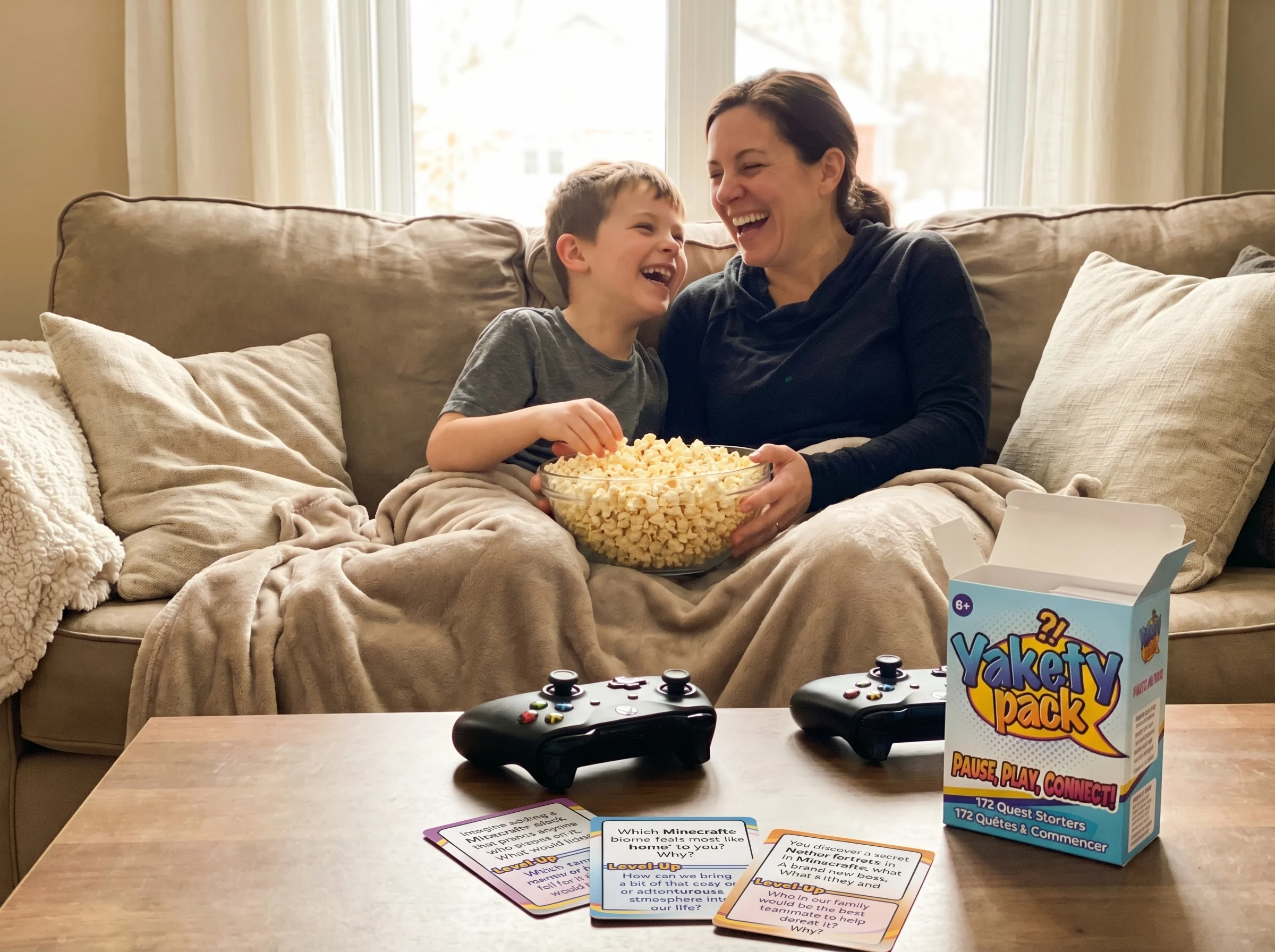 Parent and child laughing together after a game session, controllers set aside, sharing a bowl of popcorn, genuine connection